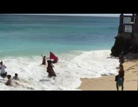 Ocean water reaches two people kneeling on sand