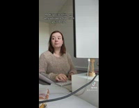Woman in beige sweater sitting in front of computer listening 
