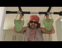 Kid dressed up as man does pull ups off of a door pull up bar, groans loudly