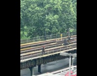 Man red cap run on train tracks bridge