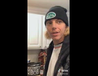 Guy taps white plate against black stove 