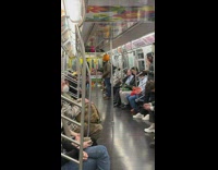 Man wearing pumpkin head riding the subway