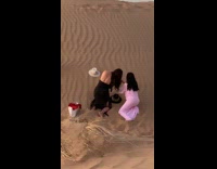 Two women dress picture hats on sand