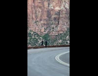 Girl dances side of road brown mountain