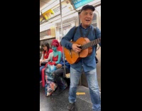 Man sings with guitar in the train