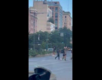 Collab WINY - Man stands on chairs like stilts cross the street