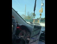 Passenger holding TV transports using convertible car