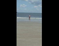 White bikini girl walks around friend sitting 