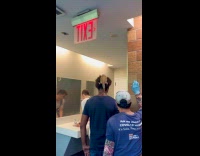 Man with large lizard pet on head