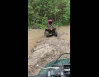 Collab SendItOfficiall - Guy drives red ATV through mud puddle