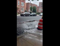 Open fire hydrant covered with construction cone