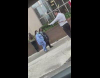 Guy exercises arms using resistance band sidewalk 