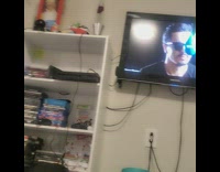 Pet cat watches cat on top of a sheep on television