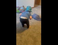 Toddler with hat twerks towards the filmer