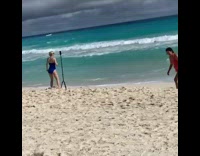 Woman blue swimsuit long tripod beach overcast