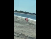 Man at beach on all fours dancing with belly