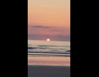 Ship silhouette pass by sunset on horizon