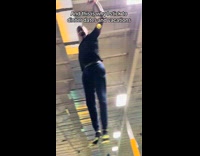 Man bounce on trampoline towards woman filming