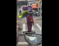 Man on street with broken umbrella arguing