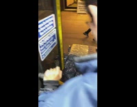 Bus stops in front of pile of garbage, passengers climb over trash bags