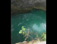 Blue shorts guy backflips rock blue water 