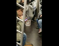 Guy makes a drum beat with white bucket and sings on subway