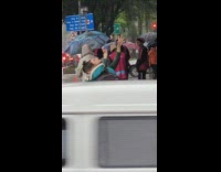 Woman red hair green outfit rain dance on the sidewalk