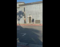 Green pants girl blue building sidewalk 