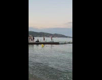 Girl hang upside down pole boardwalk beach