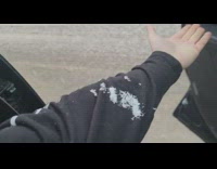 Guy open car snow fall on arm
