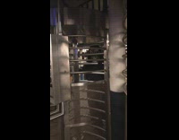 Person with bird mask and black cloak walks through subway station turnstile