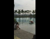 Lady poses with straw hat in pool