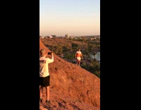 Guy orange shirt stand risky mountain slope risky