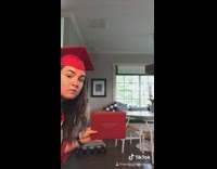 Girl shakes her own hand at graduation