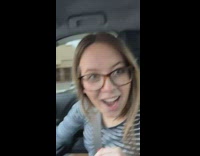 Couple in car laughing at big funny license plate 