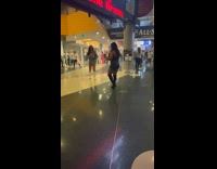 Woman crouches with a drink on the concert lobby