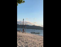 Woman swings at beach for drone video