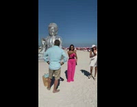 Two girls taking selfies front of statue