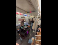 Passengers dancing to Dj playing on subway train