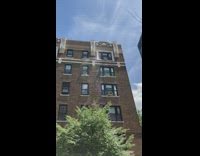 Person on apartment building shower water on street