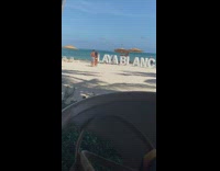Girl lie over Playa Blanca letters beach