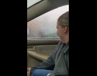 Girl break sheet of ice on car window