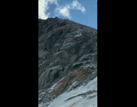 Man pushes a chunk of rock down the mountain