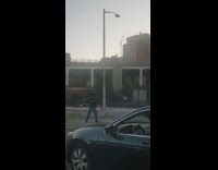 Man stands with chair on his head along road in NY 