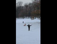 Person walks across slackline at park snow 