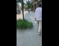 Guy holds half empty milk bottle sidewalk 