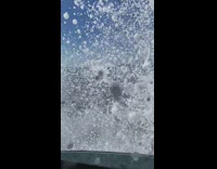 Wave breaks into rocks splashes car 