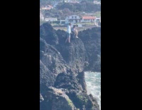 Woman pictures man on the beach rocks