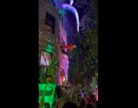 People wearing astronaut and alien costume swinging on building 