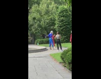 people in red suits and face masks pose at a park
